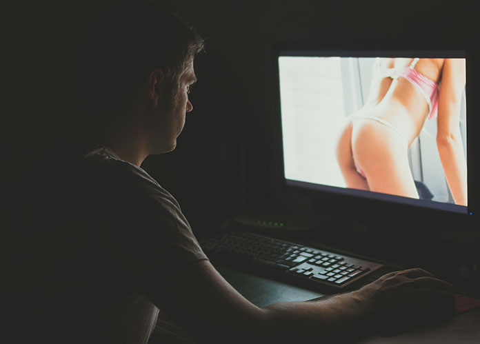 Mann schaut Pornos am PC im Dunkeln