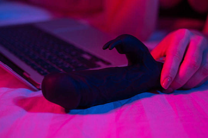 Nahaufnahme eines Vibrators neben einem Laptop